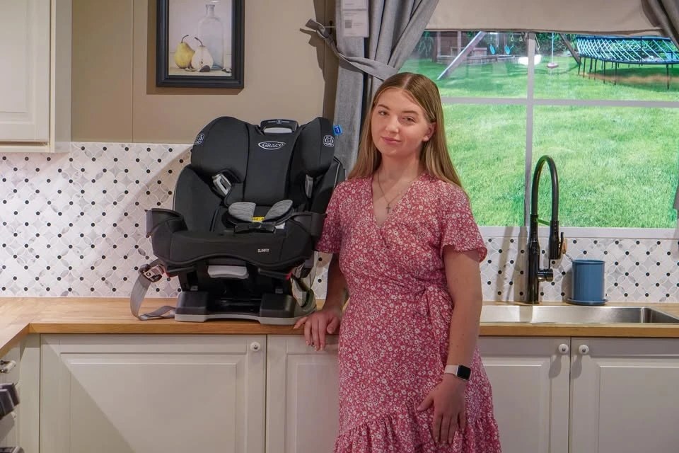 Shea, owner of SafeSeat Cleaning Co., standing next to a Graco car seat
